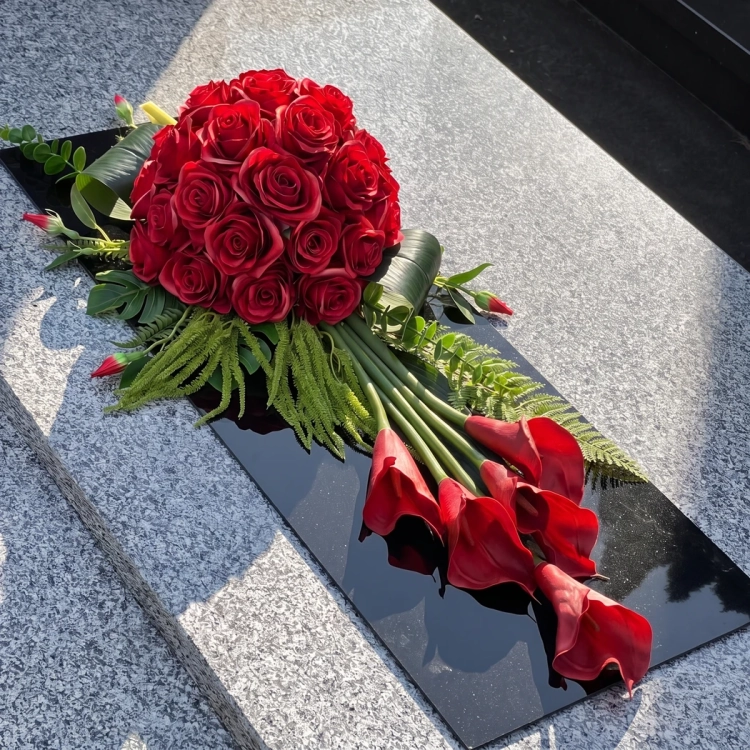 Wiązanka na cmentarz czerwona z callami, na czarnej płycie pleksi, na pomniku