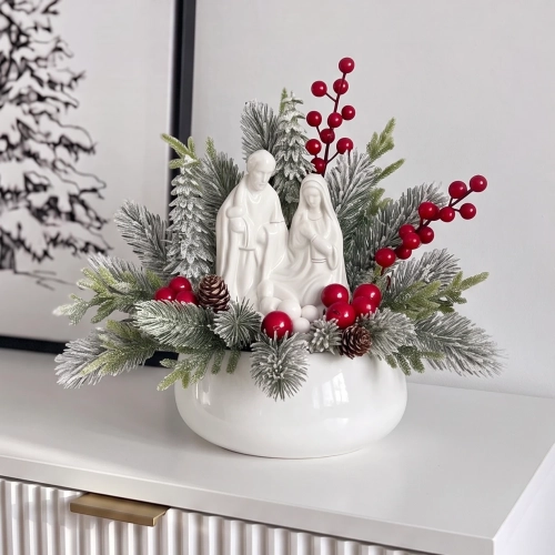 Stroik bożonarodzeniowy ze Świętą Rodziną – biała porcelanowa figurka i ośnieżone gałązki w białej misie, na komodzie