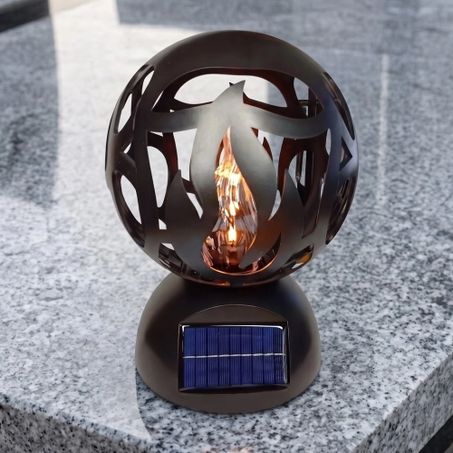 Znicz solarny LED czarny w formie ażurowej kuli z motywem płomienia, na granitowym nagrobku